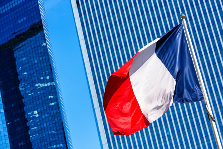French flag with business building on background